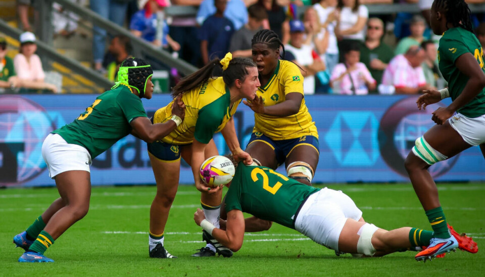 Brazil's Larissa Lima Henwood is looking for an offload in carry against a smothering South African Defence.