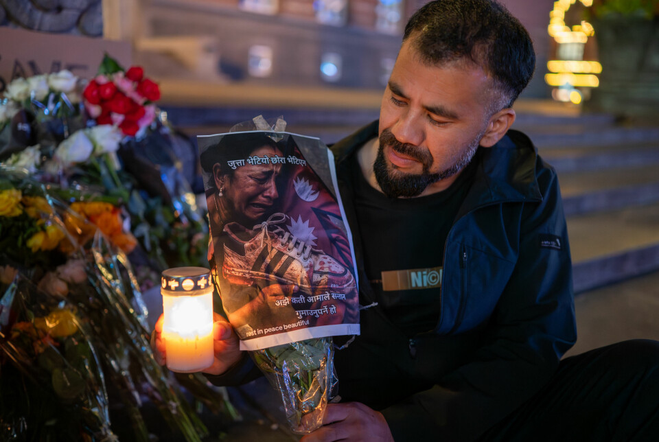 Rohan Buda, 34, from Nepal holds a picture showing a Nepali woman holding her dead son’s shoe in front of the Copenhagen City Hall on Sept. 9 . “The shoes were found, but the son was not, ” “how many mothers will have to lose their children” are printed in Nepali on the picture.