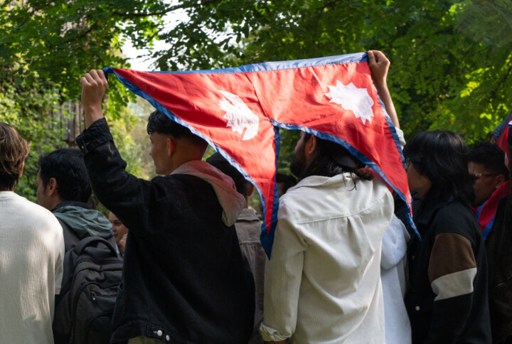 People who joined the memorial on Sept. 10 in Copenhagen wave the Nepal flag as they pose for a group photo.