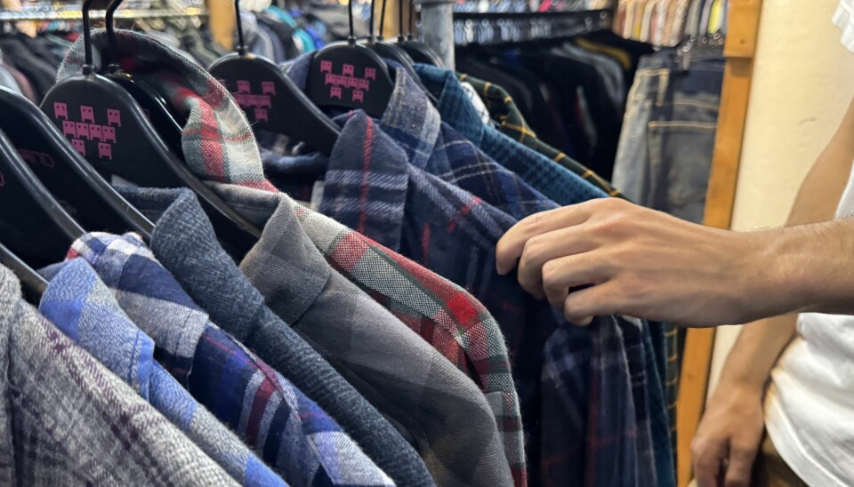 A thrift-shopper picking out second-hand clothing at Wasteland, in København K, a thrift shop just next to Quirky Lane.