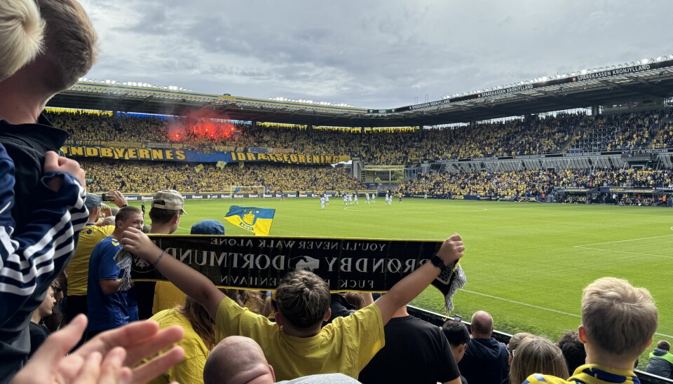 Flares lit in Sydsiden as a Brøndby supporter holds up his scarf to show support after Brøndby beat FCK 2-1 on Saturday.