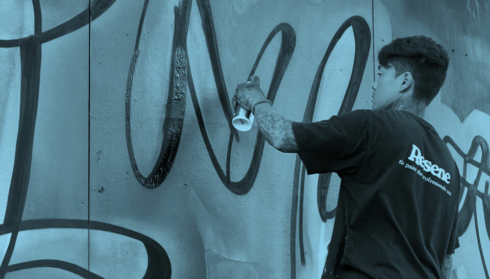 Hawaiiansk graffitimaler maler på lovlig væg.