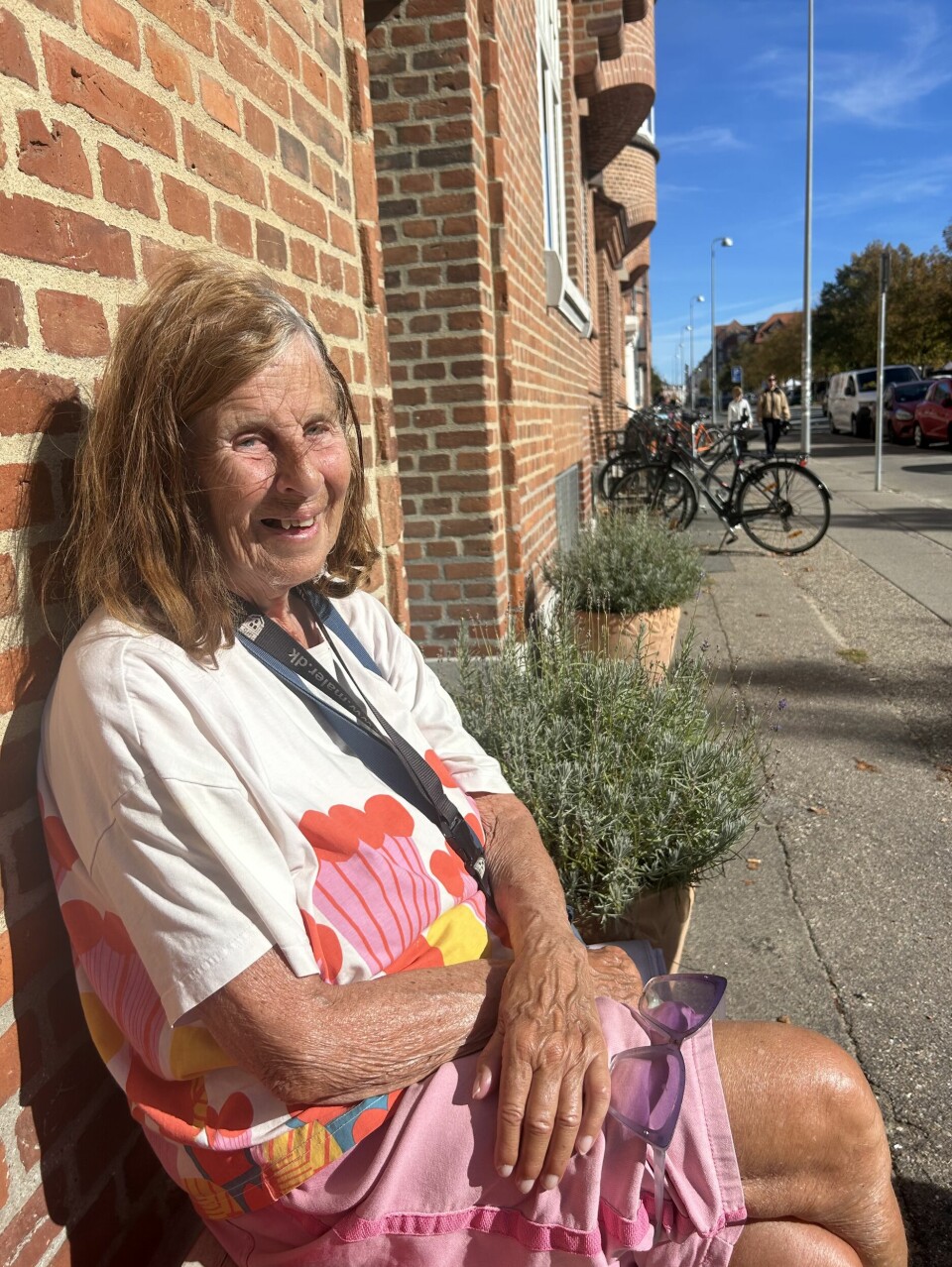 81-årige Inger Holmsten nyder at iagttage folk på bænken foran hendes lejlighed på Frederiksbjerg.
