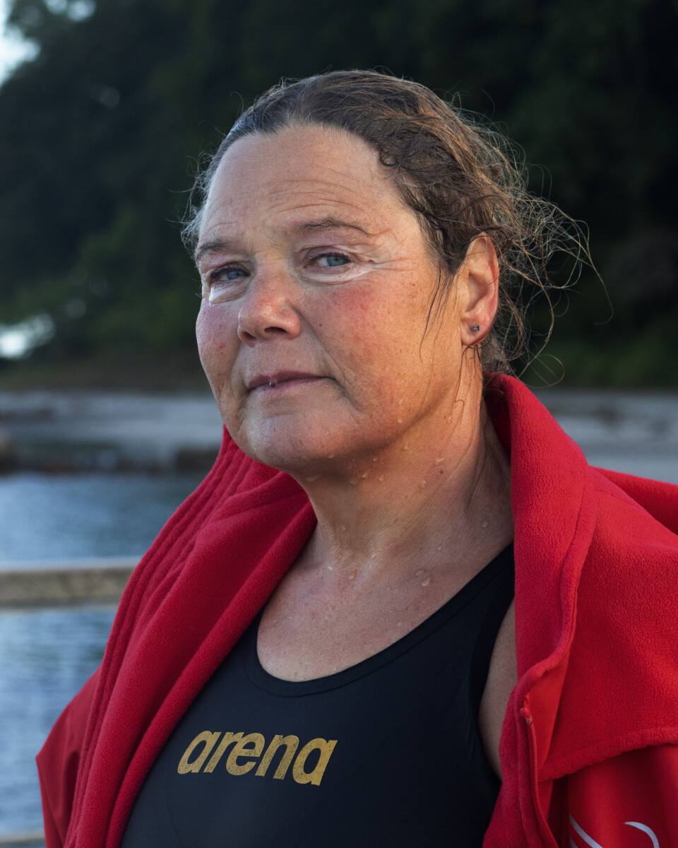 Portrait of Lene after exiting the water. She is wearing a red robe and her hair and face are wet.