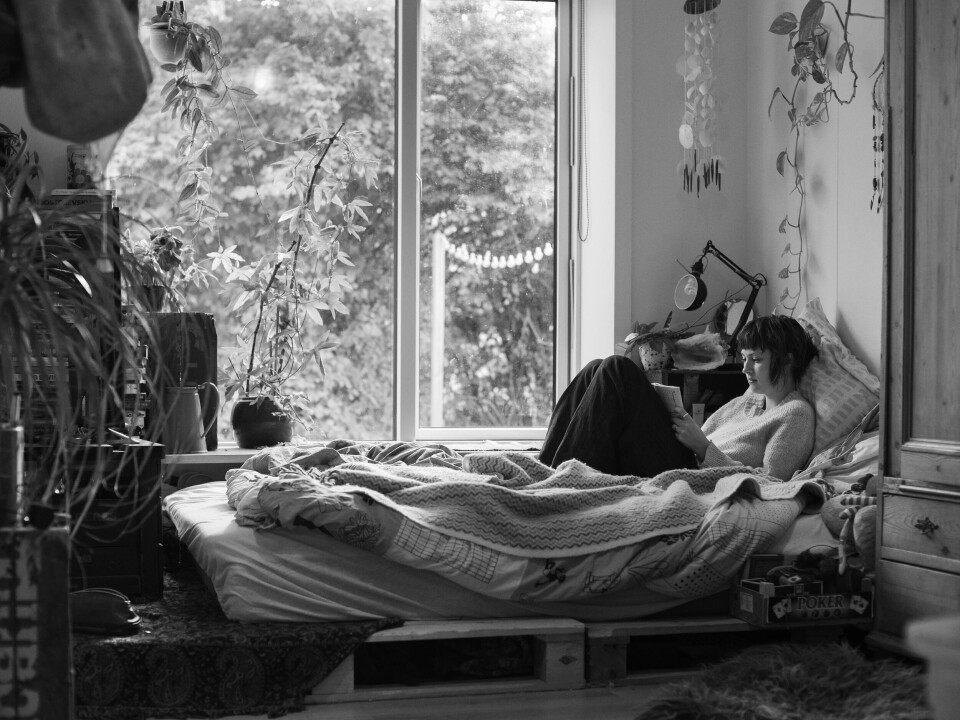 Nina is sitting on her bed by the window making sudoku.