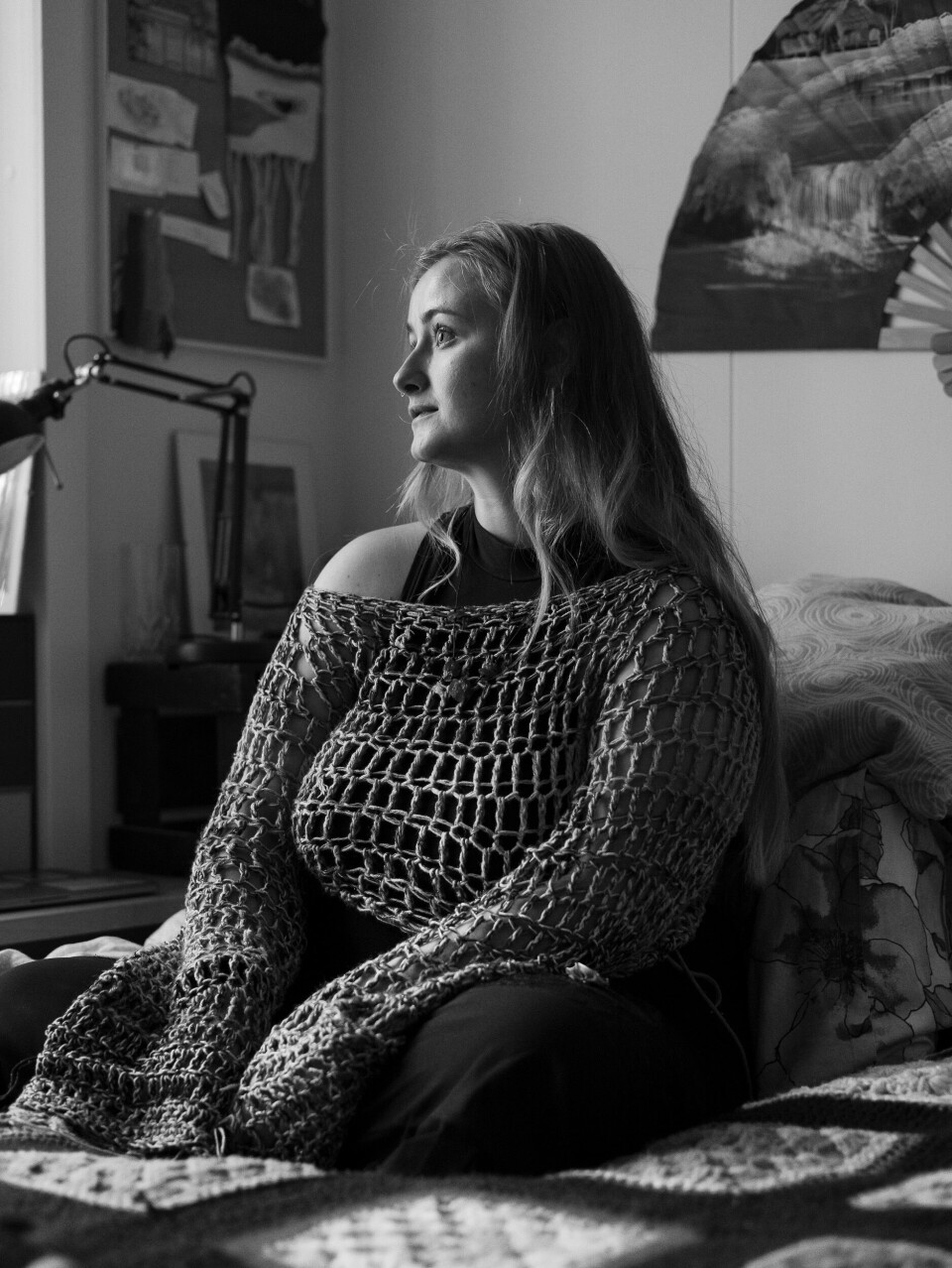 A woman sitting on her bed.