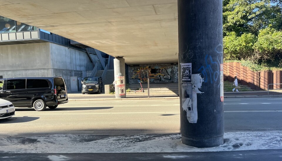 Væggen, der er dekoreret med teksten ”Aarhus the city that works for the few”, gemmer et hulrum på 3x5 meter. Her har Max Wil, omgivet af kanyler og kollaps, søgt ly for vinterkulden.