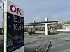 OK-tankstation med digitalt prisskilt og brændstofstandere i baggrunden
