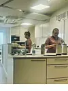 Susanne og en kollega står i køkkenet og forbereder dagens varme ret.