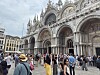 Crowds of tourists stand in front of St Mark's Basilica in Venice on a busy day.