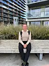 Jonas Skov sidder på en bænk foran moderne boligbyggeri på Aarhus Ø.