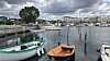 Small boats moored in Fiskerihavnen harbour with waterfront buildings and cloudy skies.